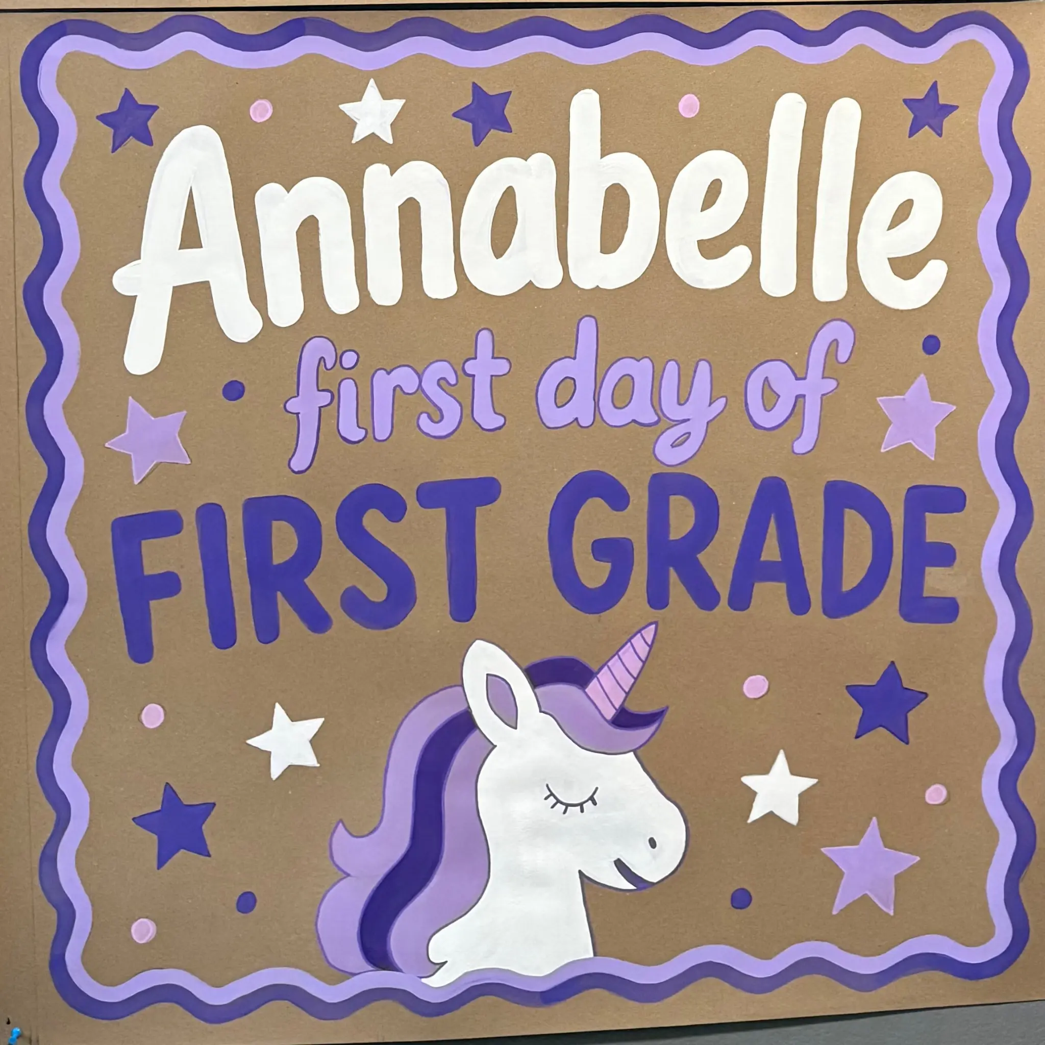 Purple first-grade unicorn banner on kraft paper